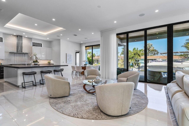 living room with recessed lighting, visible vents, and a raised ceiling