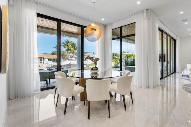 dining area with recessed lighting, a healthy amount of sunlight, marble finish floor, and expansive windows