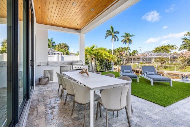 view of patio / terrace with a grill, exterior kitchen, outdoor dining space, and fence