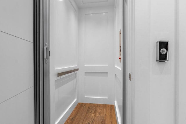 interior details featuring elevator and wood finished floors