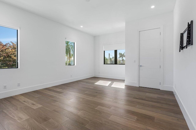 spare room with dark wood-style floors, recessed lighting, and baseboards