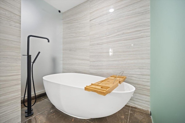 bathroom with a bath and tile walls