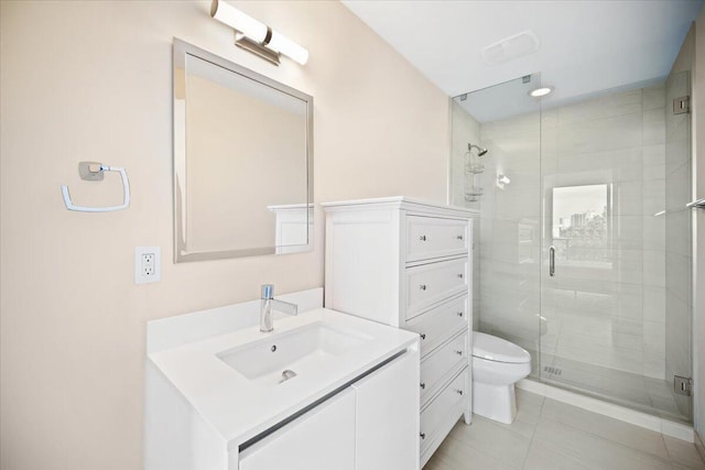 bathroom with a shower with door, vanity, tile patterned flooring, and toilet