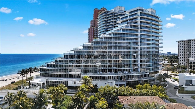 view of building exterior with a water view and a view of the beach