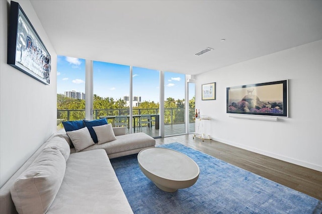 living room with dark wood-type flooring and a wall of windows