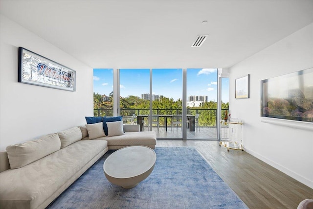 living room featuring a wall of windows and wood-type flooring