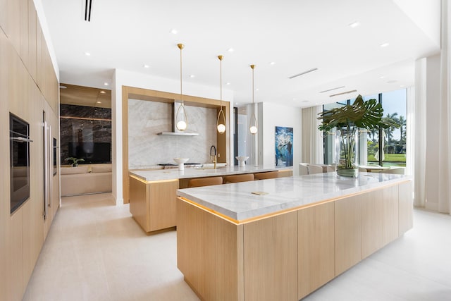 kitchen with light brown cabinetry, oven, a large island, and modern cabinets