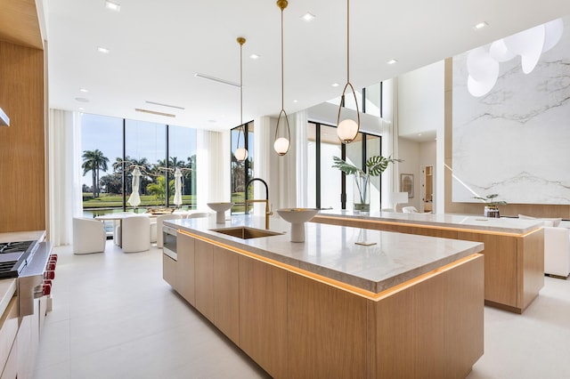 kitchen featuring an island with sink, modern cabinets, open floor plan, light countertops, and a sink