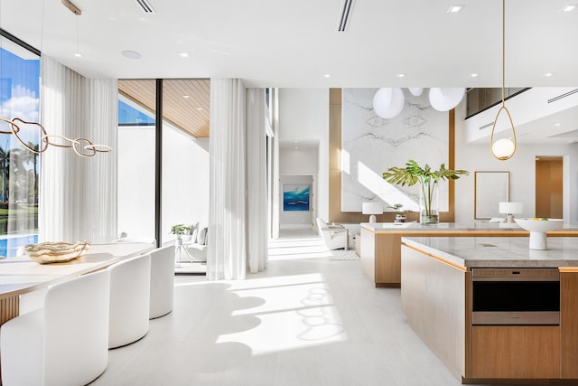 kitchen with pendant lighting, light countertops, modern cabinets, and floor to ceiling windows