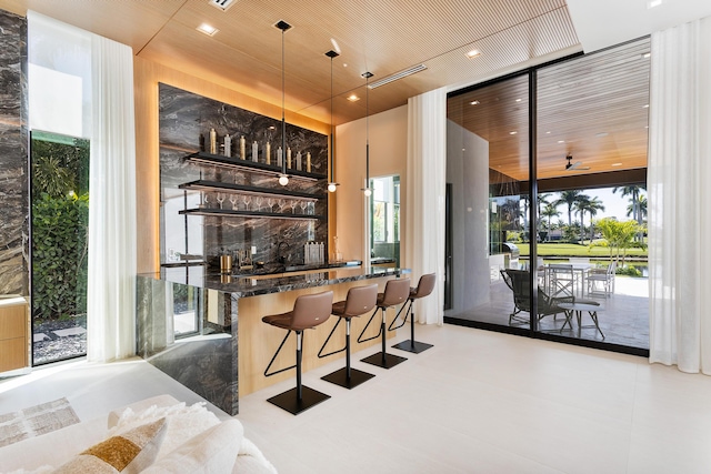 bar featuring a wall of windows, a wealth of natural light, and indoor wet bar