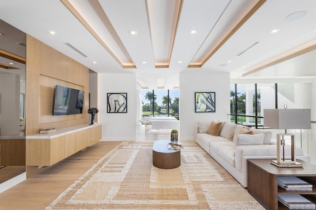 living room with visible vents, plenty of natural light, light wood-style flooring, and baseboards