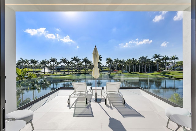 view of patio featuring a water view and a balcony