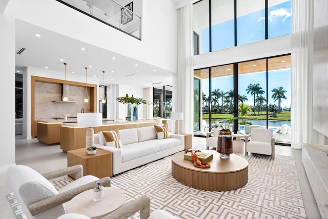 living area with visible vents, a towering ceiling, and recessed lighting