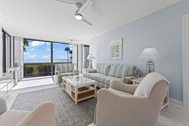 living room featuring ceiling fan and a wall of windows