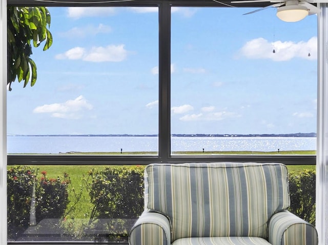 sunroom / solarium with a water view, a wealth of natural light, and ceiling fan