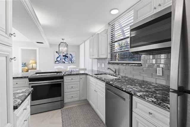 kitchen featuring sink, white cabinetry, tasteful backsplash, dark stone countertops, and stainless steel appliances