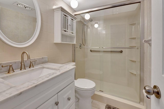 bathroom featuring toilet, an enclosed shower, tile walls, vanity, and decorative backsplash