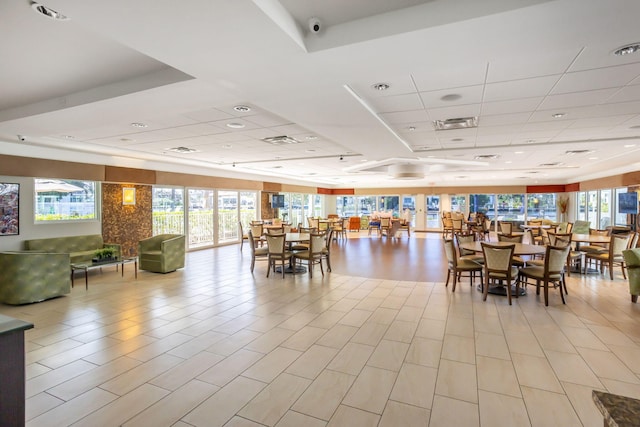 dining area featuring a wealth of natural light, a raised ceiling, and a paneled ceiling