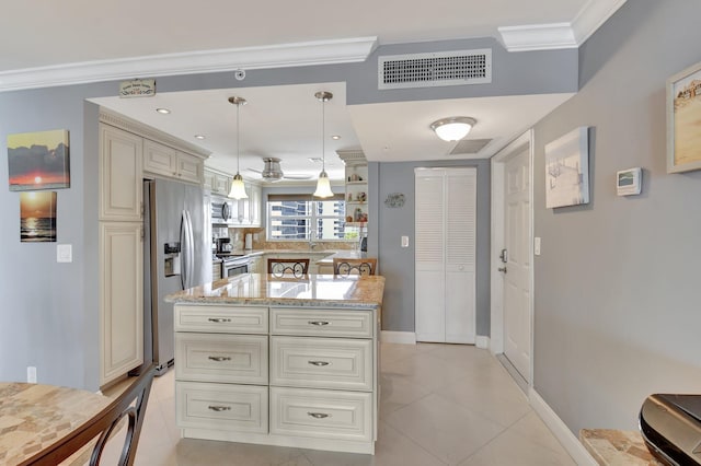 kitchen featuring crown molding, appliances with stainless steel finishes, hanging light fixtures, light stone counters, and cream cabinets