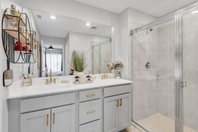 bathroom with a shower with door, vanity, and ceiling fan