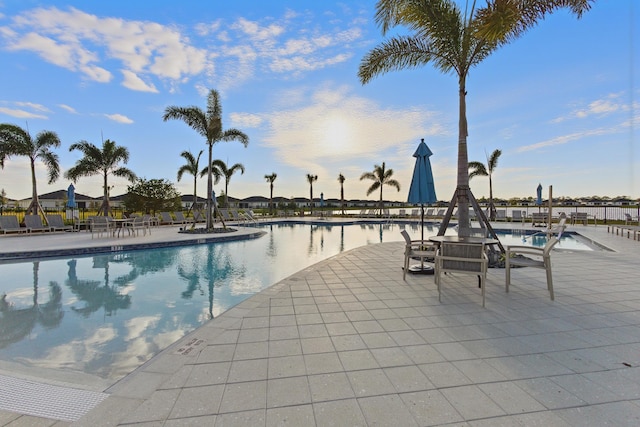 view of swimming pool with a patio area and a water view