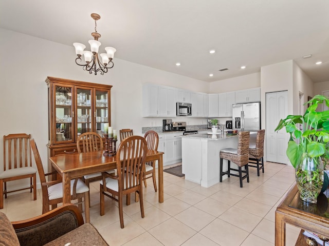 dining area featuring a notable chandelier and light tile patterned flooring