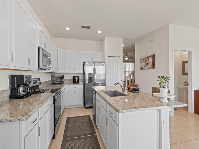 kitchen with stainless steel appliances, sink, a center island with sink, and white cabinets