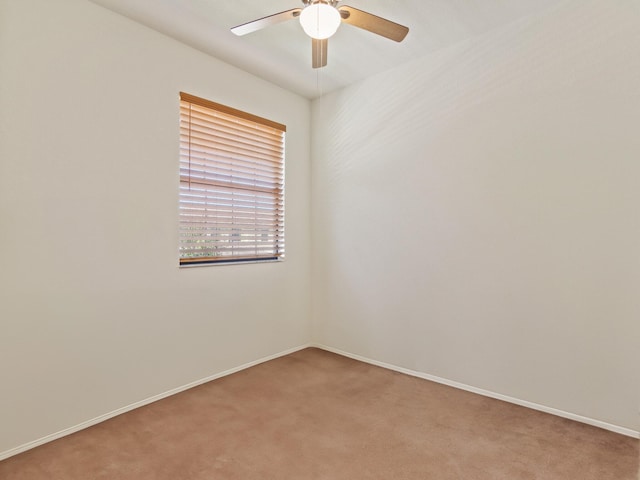 carpeted spare room featuring ceiling fan