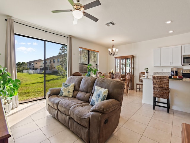 tiled living room featuring ceiling fan with notable chandelier