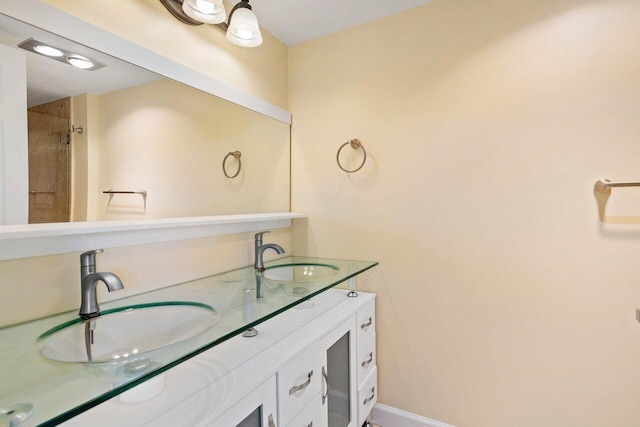 bathroom with tiled shower and vanity