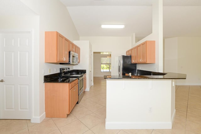 kitchen featuring lofted ceiling, light tile patterned floors, a kitchen breakfast bar, kitchen peninsula, and stainless steel appliances