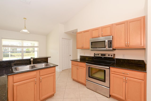 kitchen with vaulted ceiling, pendant lighting, sink, light tile patterned floors, and stainless steel appliances