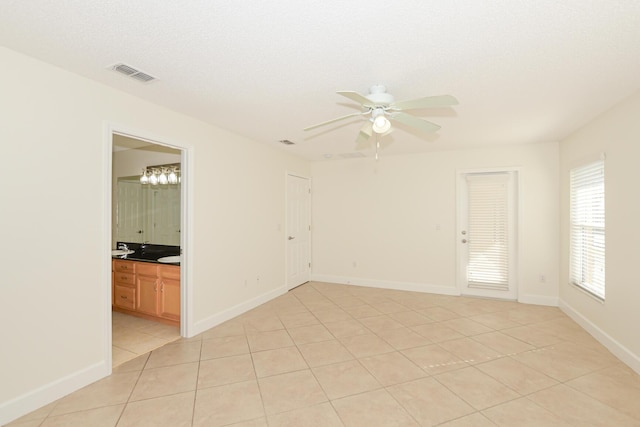 unfurnished room with light tile patterned flooring, ceiling fan, and a textured ceiling