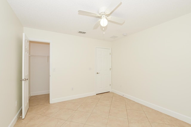 tiled spare room featuring a textured ceiling and ceiling fan