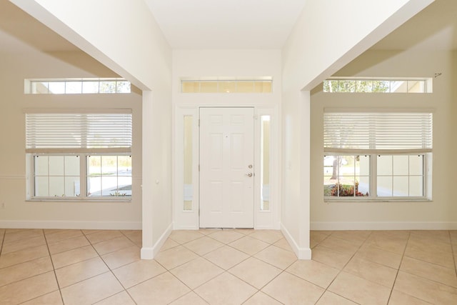 entryway with a healthy amount of sunlight and light tile patterned flooring