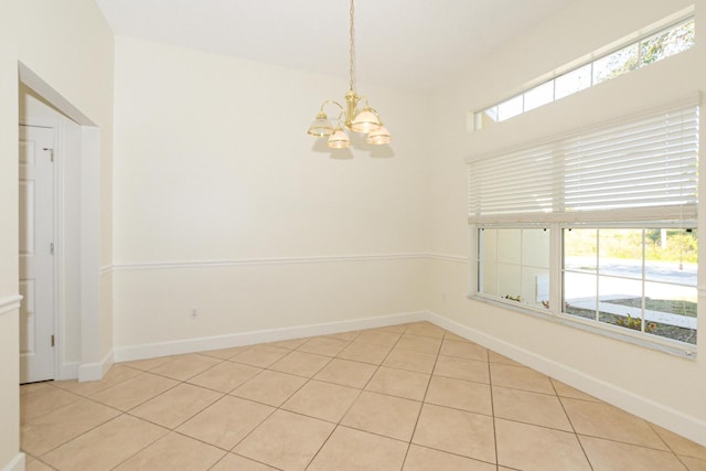 tiled empty room with a chandelier