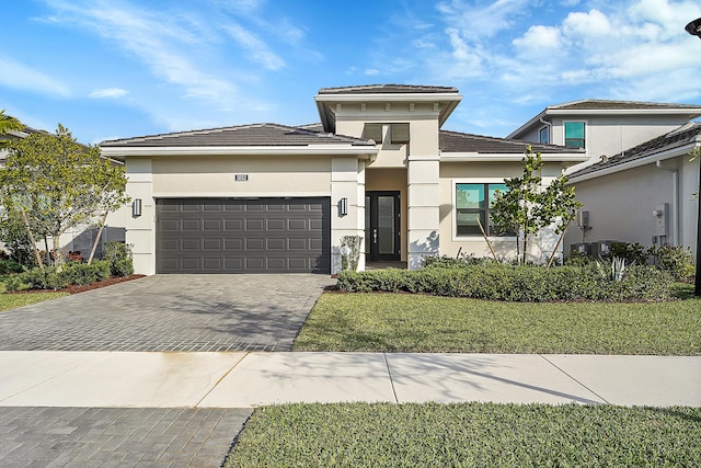 prairie-style home with a garage and a front lawn