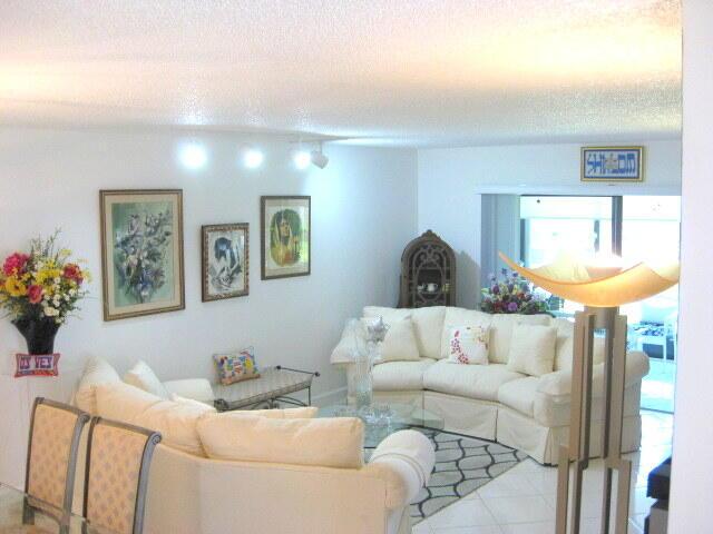 tiled living room featuring a textured ceiling