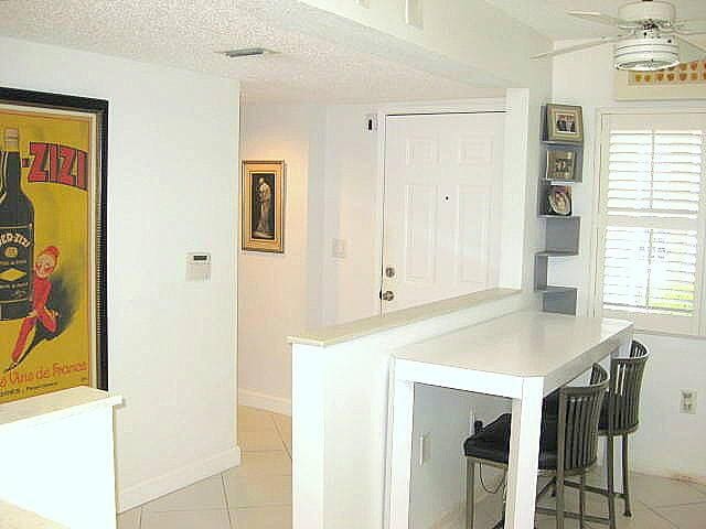 kitchen with light tile patterned flooring, a breakfast bar, a textured ceiling, kitchen peninsula, and ceiling fan