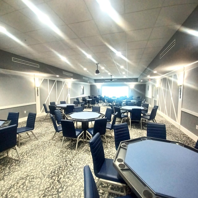 carpeted dining space with a drop ceiling