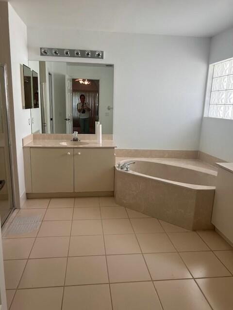 bathroom featuring tile patterned flooring, vanity, and shower with separate bathtub