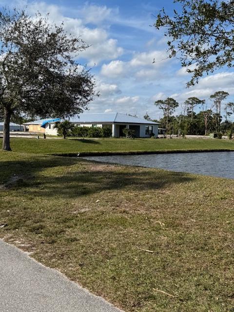 surrounding community featuring a water view and a lawn