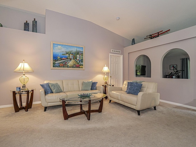 carpeted living room with high vaulted ceiling