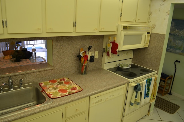 kitchen with sink, light tile patterned floors, white appliances, and decorative backsplash