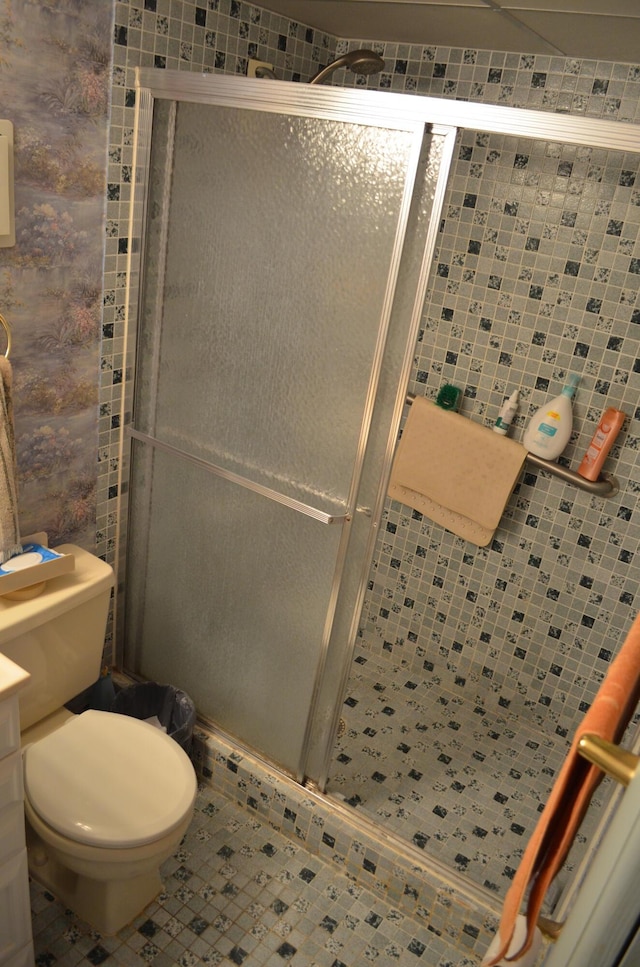 bathroom with tile patterned floors, toilet, and an enclosed shower