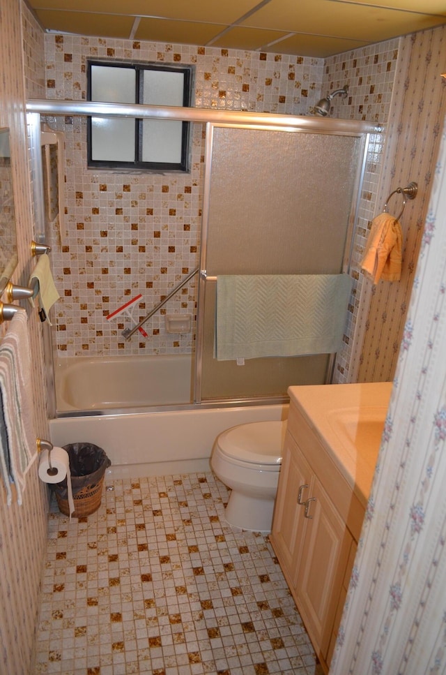 full bathroom featuring bath / shower combo with glass door, vanity, and toilet