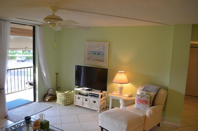 living room featuring ceiling fan, light tile patterned floors, and a textured ceiling