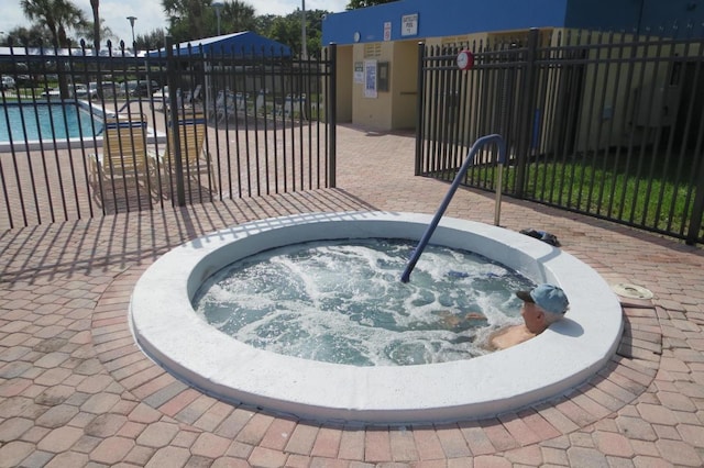 view of patio with a swimming pool with hot tub