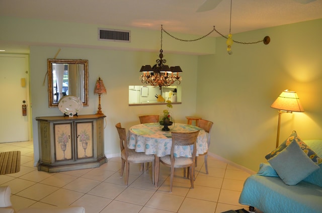 tiled dining area featuring a notable chandelier