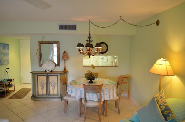 dining room with light tile patterned floors and an inviting chandelier